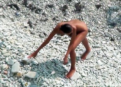 Жопастая девушка позирует на пляже голая с затычкой в анусе