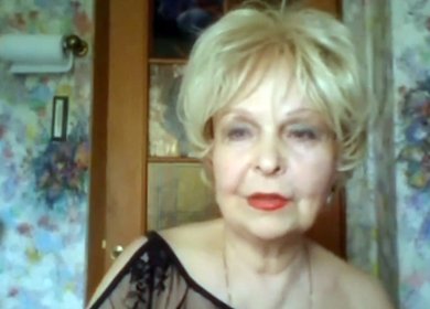 Женщина 65 лет в прозрачном пеньюаре показывает увядшие прелести