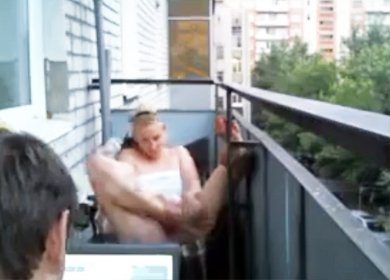 Телочка в полотенце расставляет ножки на балконе